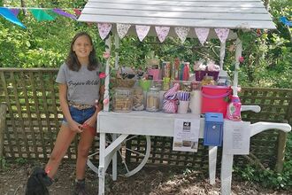Izzy, 13, stands proudly by her sweet stall on the bissoe trail