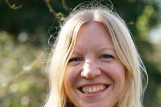 A woman with blond hair smiles at the camera
