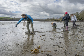 People walking across mud in waders