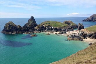 kynance cove on the south west coast path in cornwall, turquoise beautiul seas and blue skies