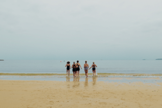 A group of women heading into the sea for a swim