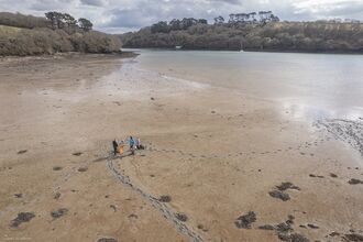 Aerial view of people standing on a tidal mudflat at low tide