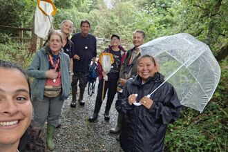 A group of people stood with recording equipment in the rain