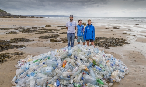 Bottle mountain on Cornish beach with ReFILL Cornwall team behind, photo by Symages