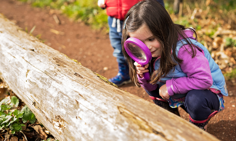 Child with magnifying glass. Staffordshire Wildlife Trust