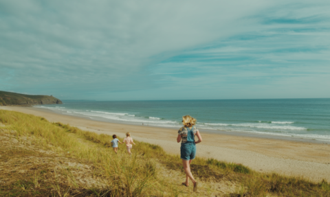Family running wild on a south Cornish beach.