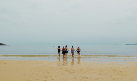 A group of women heading into the sea for a swim