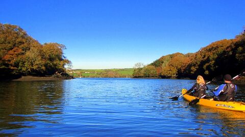 Blue skies over a river with a yellow kayak on the right of the image