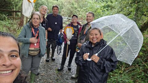 A group of people stood with recording equipment in the rain