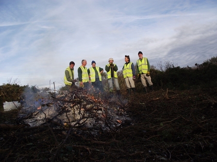 Volunteers tending a fire after a day's scrub clearance