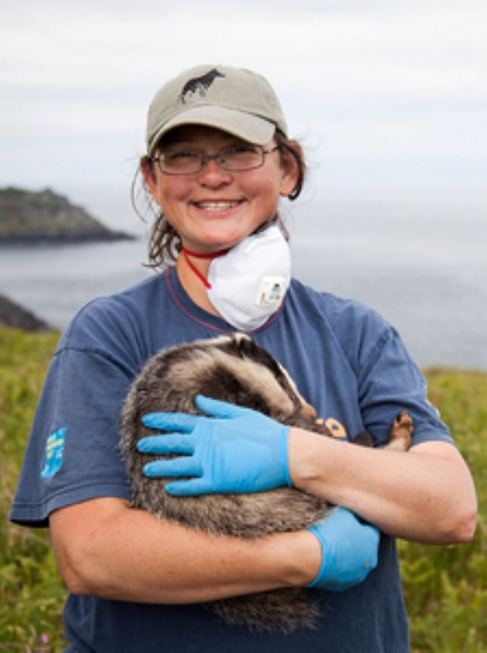 Image of a person smiling and holding a badger