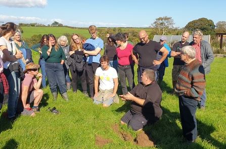 People stood in a field listening to a talk about soil