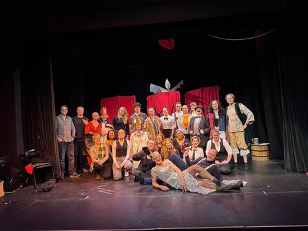 The cast of CHOUGHS panto is gathered together for a group, on stage, photo. 