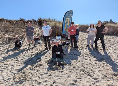 People stood on a beach around a Making Space for Sand 