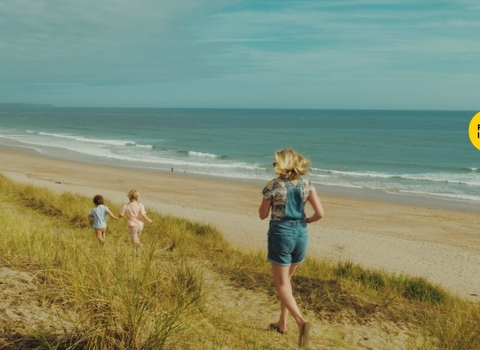 Family running wild on a south Cornish beach.