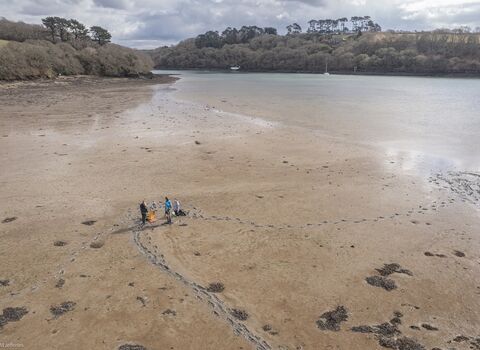 Aerial view of people standing on a tidal mudflat at low tide